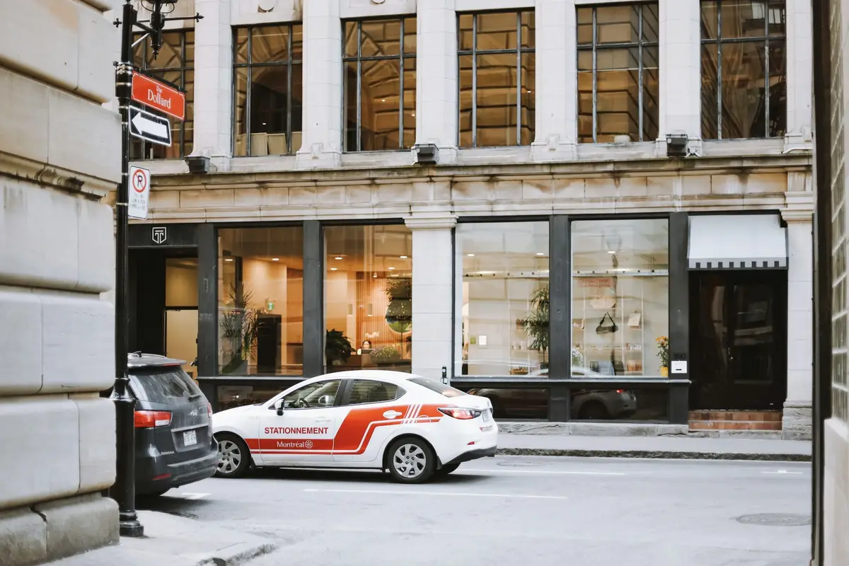 A stone building with tall ground-floor shop windows on a city street